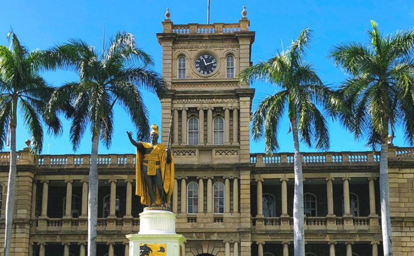 ホノルルのアリイオラニ・ハレ（ハワイ州最高裁判所）の前に立つ、金色のマントを羽織ったカメハメハ大王像