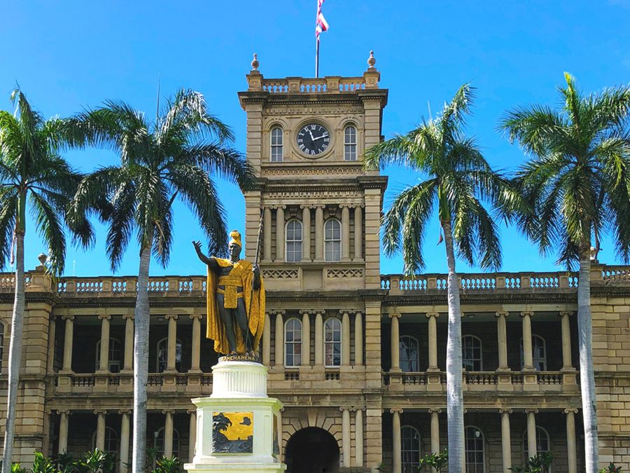 ホノルルのアリイオラニ・ハレ（ハワイ州最高裁判所）の前に立つ、金色のマントを羽織ったカメハメハ大王像